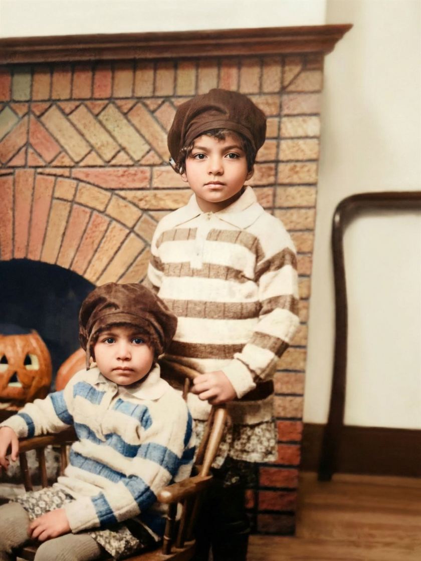 After: the two children by a brick fireplace, restored in color